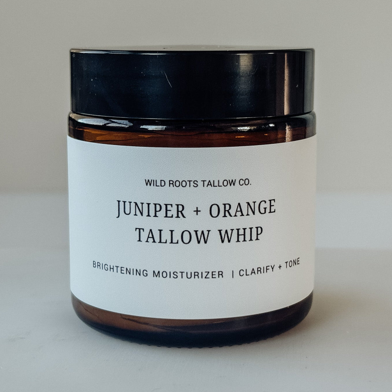 Jar of Juniper + Orange Tallow Whip from Wild Roots Tallow Co. on a neutral background