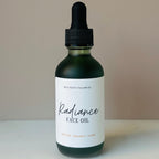 Bottle of Radiance Face Oil with a dropper on a neutral background