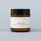 Jar of Vanilla Whipped Tallow Body Butter from Wild Roots Tallow Co on a wooden surface with a light gray background