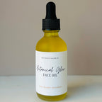 Bottle of Botanical Glow Face Oil with dropper on a neutral background