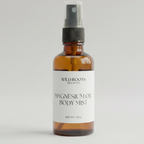 Bottle of Wild Roots Magnesium Oil Body Mist on a countertop with boxes and a plant in the background.